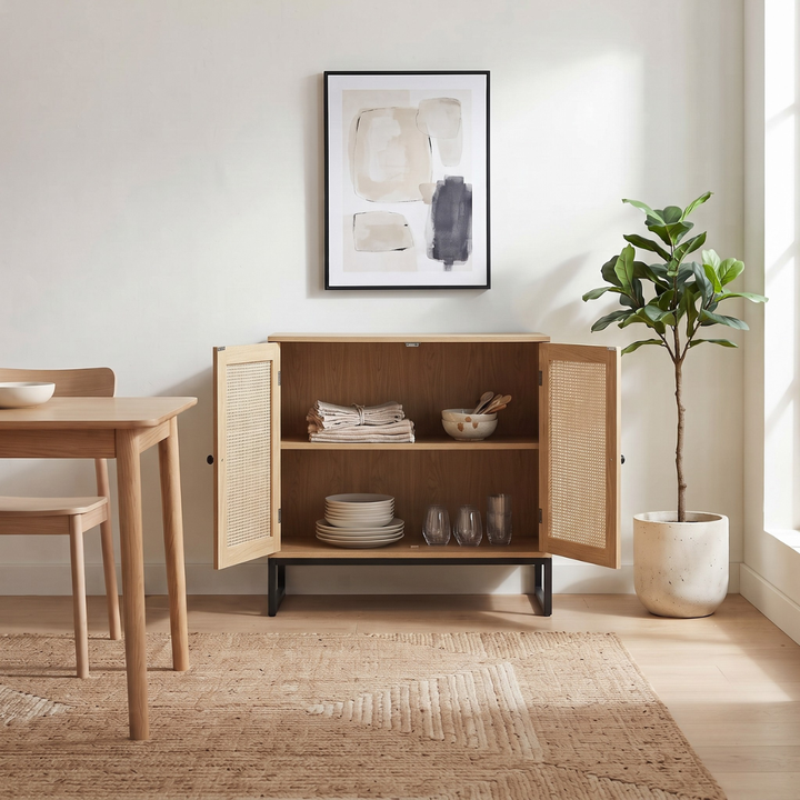 Aparador Buffet de color madera clara con dos puertas de ratán y base de metal negro en estilo nórdico.