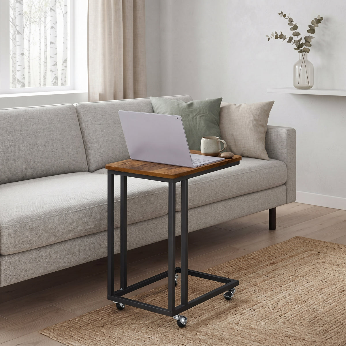 Mesa auxiliar en C Vendel con notebook junto a un sofá
