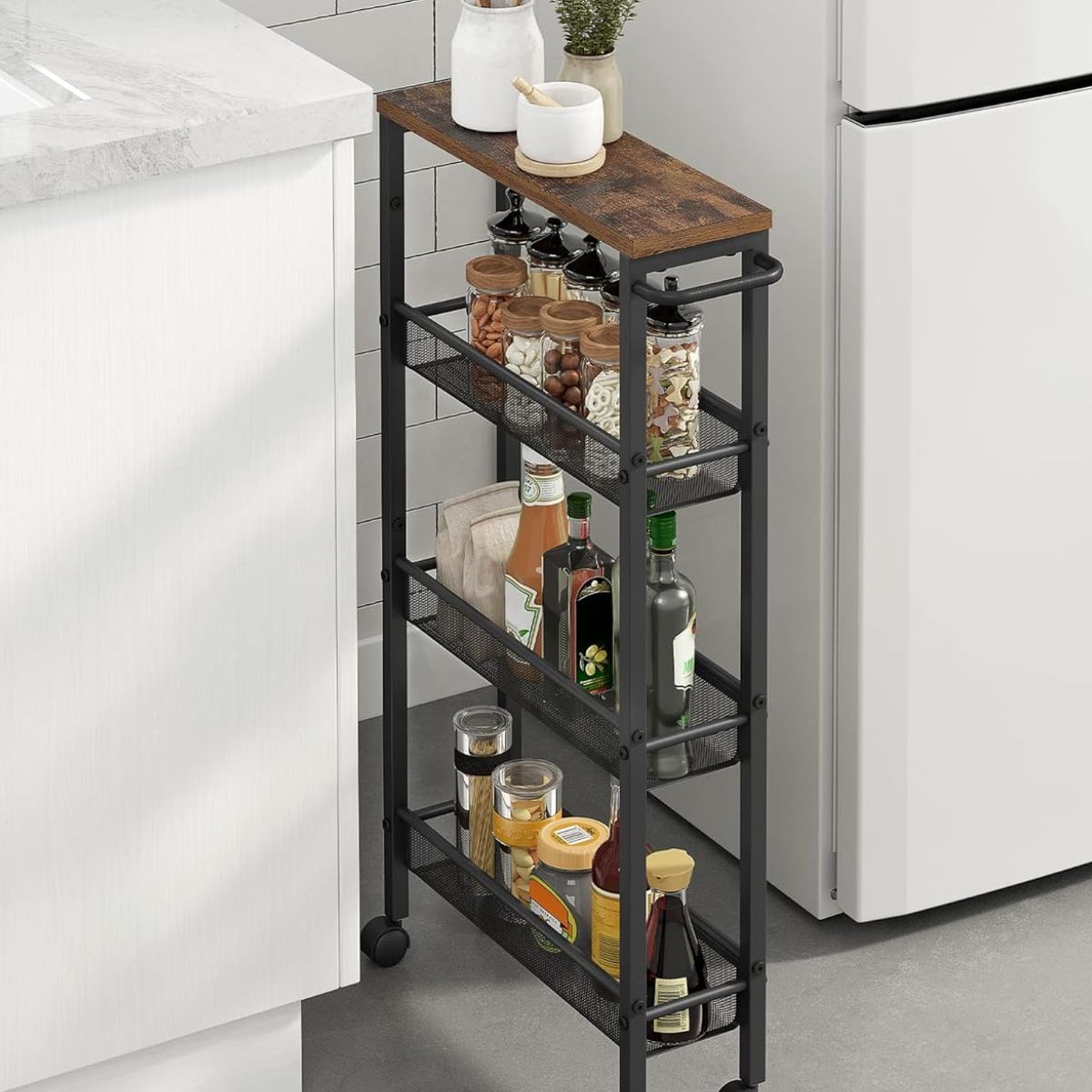 Carrito de cocina angosto Vestre junto al refrigerador con condimentos